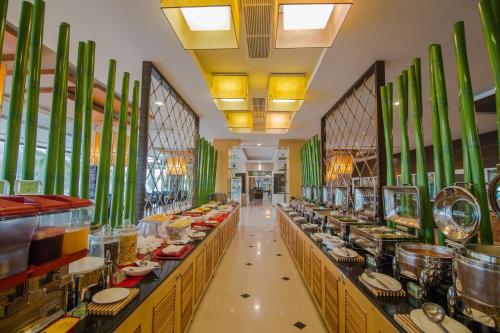 a restaurant with a long line of tables with food at MBI Resort Danok in Sadao