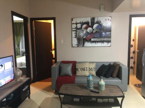 een woonkamer met een bank en een salontafel bij SAN LORENZO PLACE 2BR 29-E by LARICO in Manilla