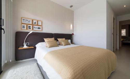 a bedroom with a large bed with a black headboard at Sunset Drive Benidorm by Mar Holidays in Benidorm
