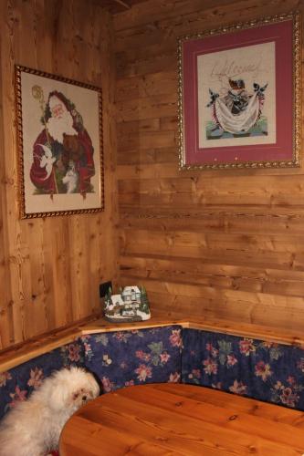 a dog sitting on a bench in a room at Hotel Des Roses in Antey-Saint-André
