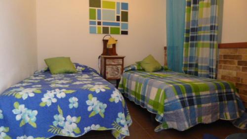 a bedroom with two beds with green and blue sheets at A Casa da Maria in Tavira