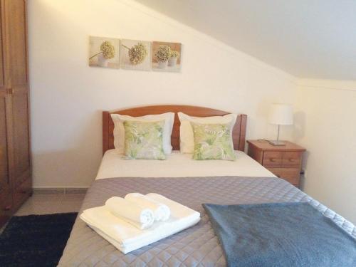a bedroom with a bed with two towels on it at Casa BeijoMar in Nazaré