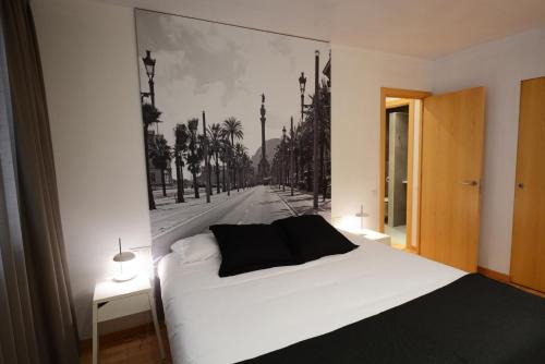 a bedroom with a white bed with a painting on the wall at Apartments Hotel Sant Pau in Barcelona