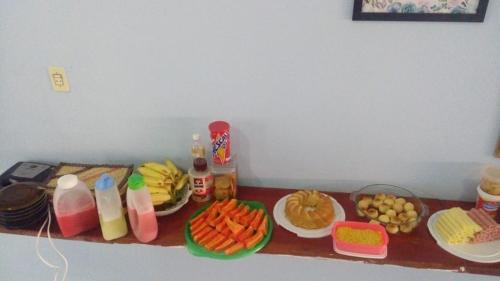 uma mesa coberta com pratos de comida e bebidas em Pousada Azul da Broadway em Canoa Quebrada