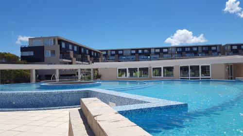 a large swimming pool in front of a building at Apart Spa Linda Bay in Mar de las Pampas