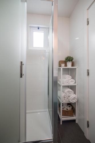 a shower with a glass door in a bathroom at Casa dos Mouros in Évora