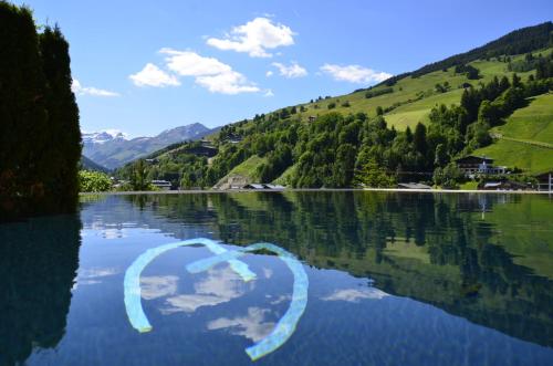 a body of water with a reflection in the water at Alpin Juwel - Bio und Lifestylehotel in Saalbach Hinterglemm