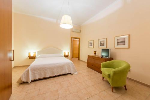 ナポリにあるLa Residenzaのベッドルーム(ベッド1台、椅子、テレビ付)