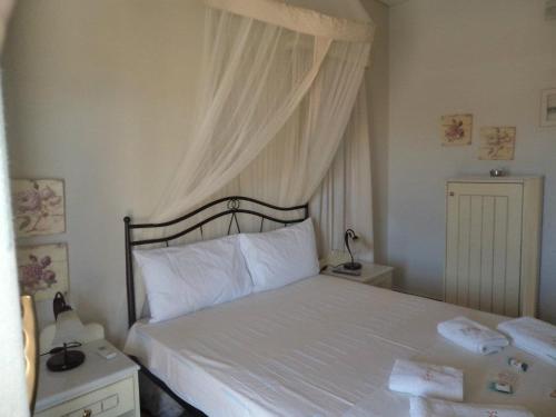 1 dormitorio con 1 cama blanca con dosel en Fanos Studios en Koufonisia
