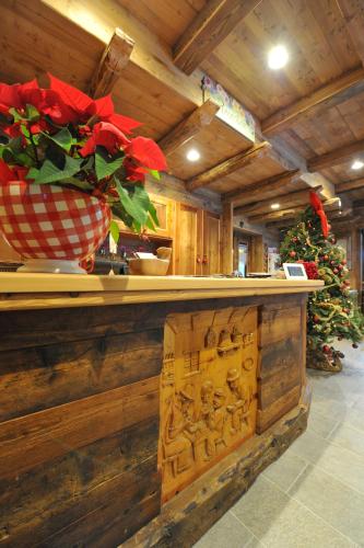 a counter with a vase on it with a christmas tree at Hotel Des Roses in Antey-Saint-André