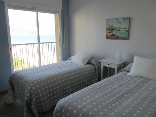 מיטה או מיטות בחדר ב-Primera linea de mar