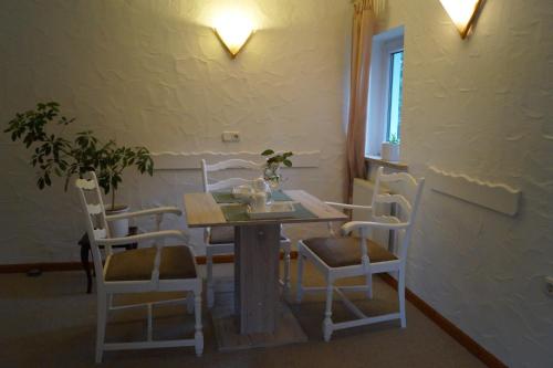 ein Esszimmer mit einem Tisch und 4 Stühlen in der Unterkunft Ferienwohnung Shamrock in Hahnenklee-Bockswiese