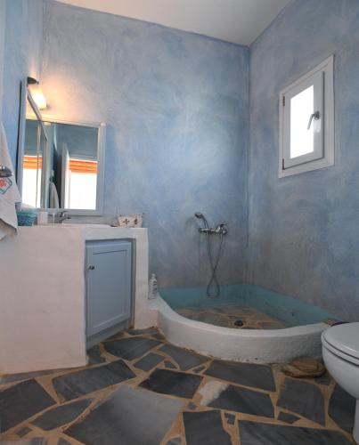 a bathroom with a tub and a toilet at Villa Areti in Tinos
