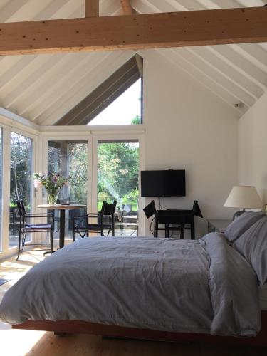 a bedroom with a bed and a table and chairs at The Studio @ Aubrey Cottage in Chichester