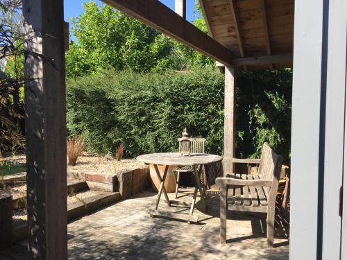 a patio with a table and a chair at The Studio @ Aubrey Cottage in Chichester