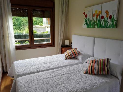 2 camas en un dormitorio con ventana en Descanso en el Sella, en Cangas de Onís