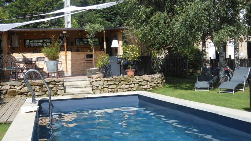 a swimming pool in a yard with a house at Domaine de Sault in Dore-lʼÉglise