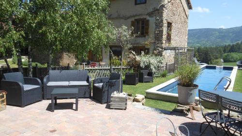 a patio with chairs and a pool in front of a house at Domaine de Sault in Dore-lʼÉglise