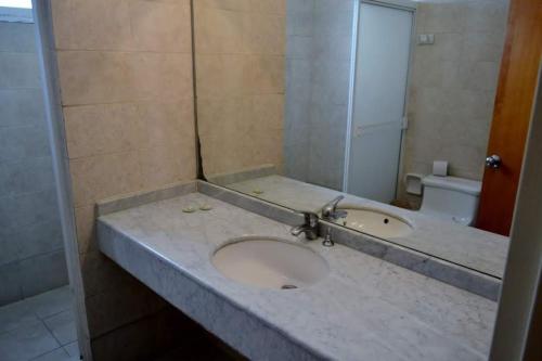 a bathroom with a sink and a mirror at Hotel Coliseo in Caracas