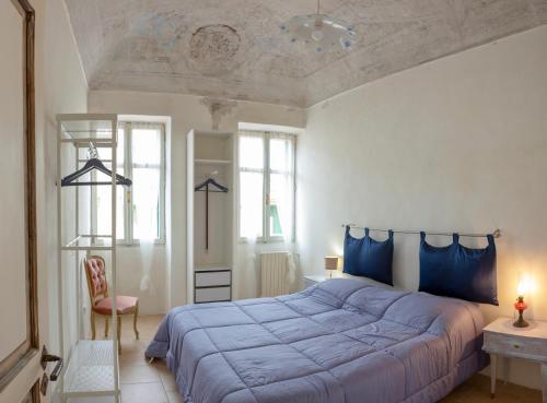 ein Schlafzimmer mit einem großen Bett mit blauer Bettwäsche in der Unterkunft Domus Napoleone Bonaparte in Sanremo