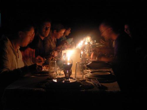 Eine Gruppe von Menschen, die mit einer Kerze am Tisch sitzen in der Unterkunft ATTA Rainforest Lodge in Surumatra