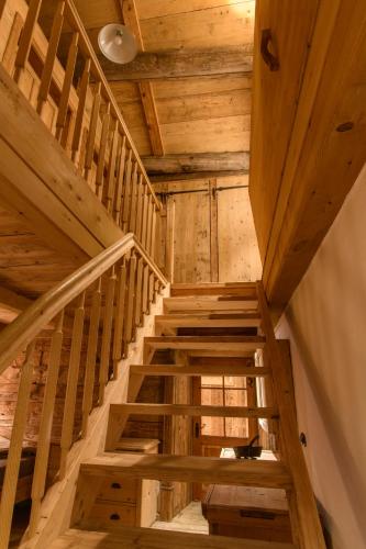 a wooden staircase with a cat sitting in the middle at Chalet Berghaus Bartholomäberg in Bartholomäberg