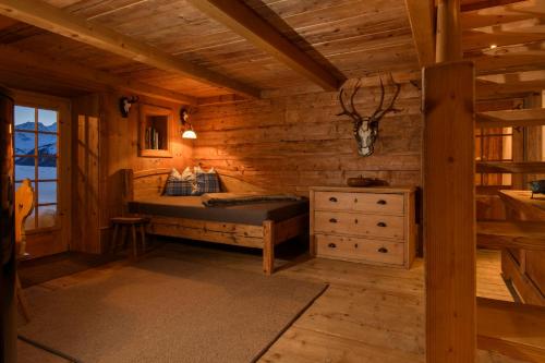 a bedroom in a log cabin with a bed and a dresser at Chalet Berghaus Bartholomäberg in Bartholomäberg