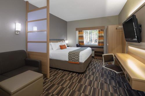 um quarto de hotel com uma cama e uma televisão de ecrã plano em Microtel Inn & Suites by Wyndham Florence em Florence