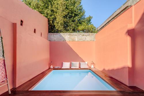 an outdoor swimming pool in a building with an orange wall at VIVA Casa da Praça with heated Pool and Terrace in Porto