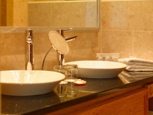 two sinks on a counter in a bathroom at Diamond Coast Hotel in Enniscrone
