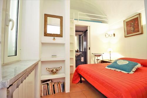 Un dormitorio con una cama roja y un espejo. en holidaycasa Brandy- A picco sul mare, en Sperlonga
