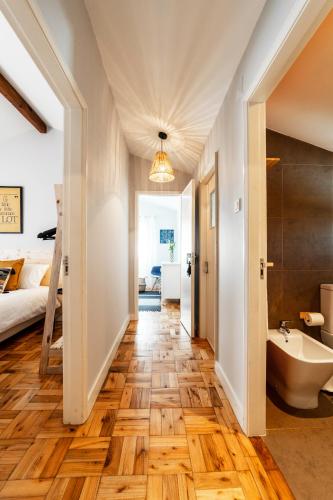 a bathroom with a wooden floor and a bed and a tub at BeachLiving Cortegaça in Cortegaça