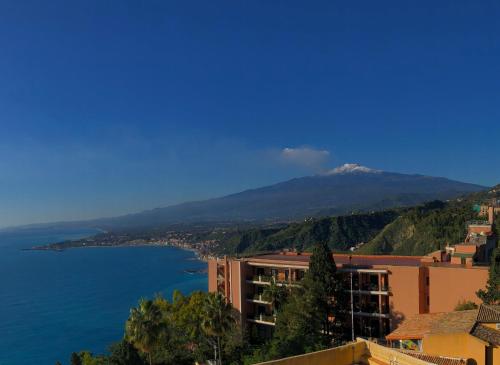 a view of a mountain and a body of water at Hotel Elios Tao in Taormina
