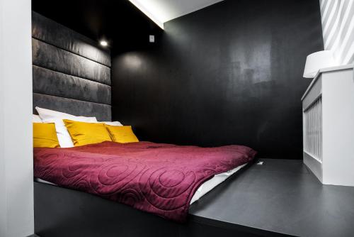 a bedroom with a bed with yellow and red pillows at Apartament Rynek22 in Kazimierz Dolny