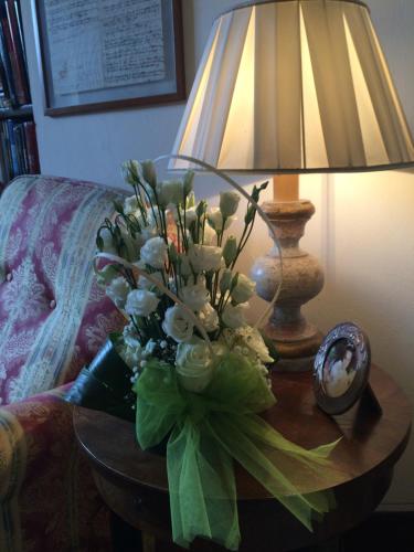 a vase of flowers on a table next to a lamp at Hotel Santa Caterina in Siena