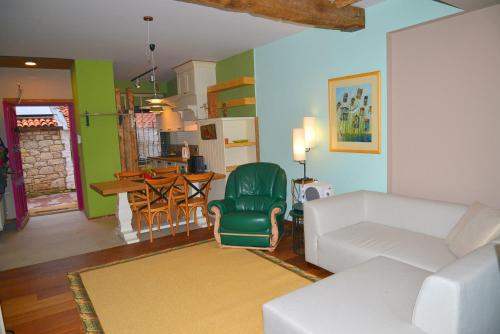 sala de estar con sofá blanco y silla verde en Alacati Suites, en Alacati