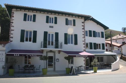 Un grand bâtiment blanc avec volets verts dans l'établissement Hôtel/Restaurant C'Vall, à Urepel