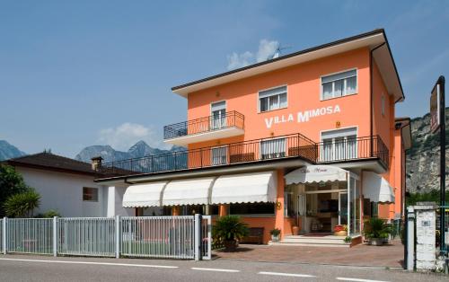 a orange building with a fence in front of it at Albergo Villa Mimosa in Nago-Torbole
