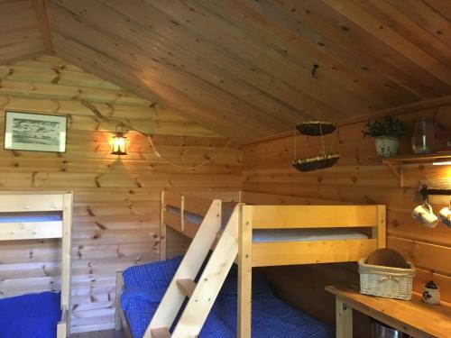 a bedroom in a log cabin with bunk beds at Cabin on Husky Farm in Strömsund