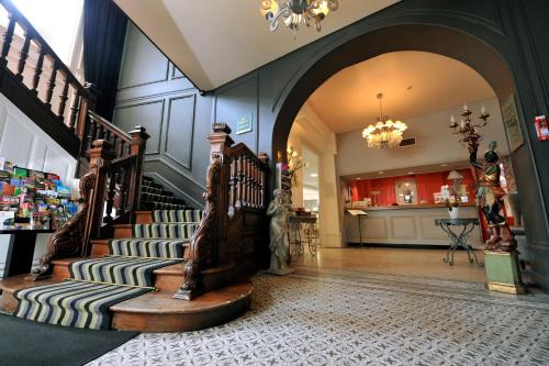 - un salon avec un escalier dans une maison dans l'établissement LOGIS Hôtel de Bourgogne - Mâcon, à Mâcon