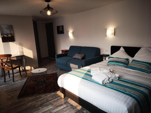 UrepelにあるHôtel/Restaurant C'Vallのベッドルーム1室(ベッド1台、青いソファ付)、
