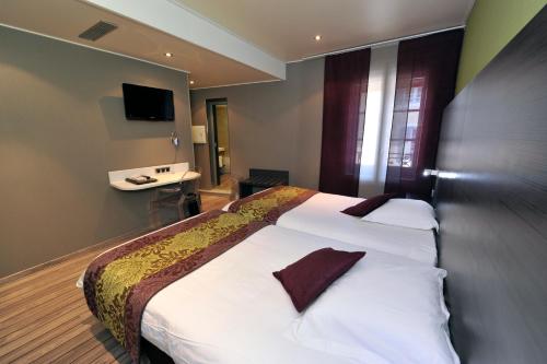 a hotel room with a large bed and a television at LOGIS Hôtel de Bourgogne - Mâcon in Mâcon