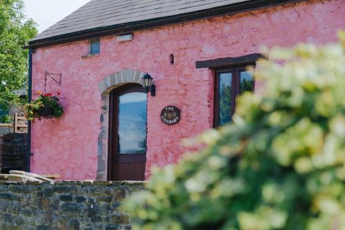 a red brick building with a door and a window at The Granary in Bridgend