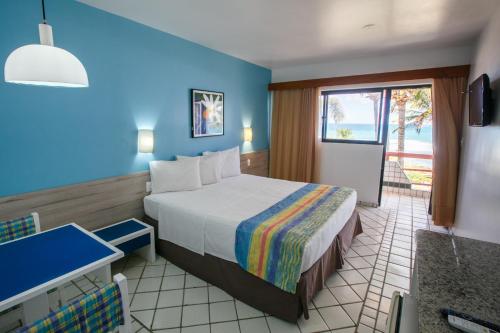 a hotel room with a bed and a bathroom at Hotel Canarius D'Gaibu in Cabo de Santo Agostinho