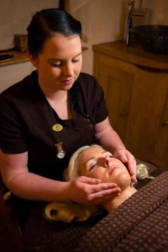 a woman is washing the face of a woman at Lake Vyrnwy Hotel & Spa in Llanwddyn