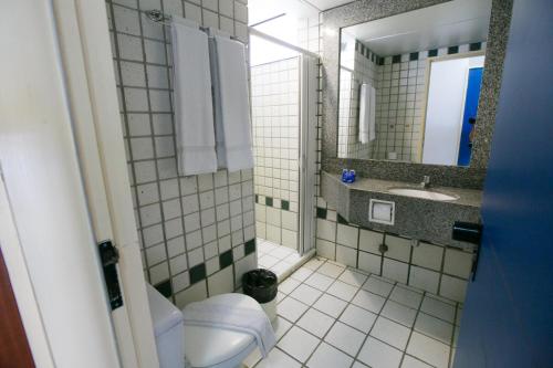 uma casa de banho com um WC, um lavatório e um espelho. em Hotel Canarius D'Gaibu em Cabo de Santo Agostinho