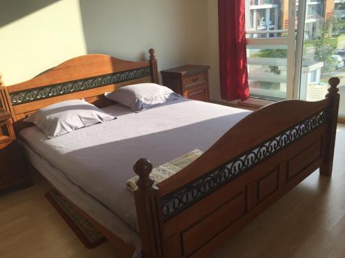 a large wooden bed in a bedroom with a window at Zolitūdes iela Leilighet in Riga