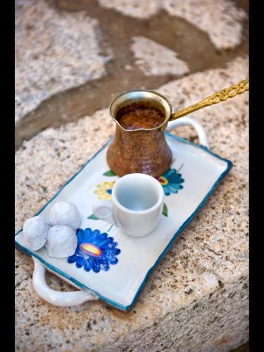 a cup of coffee and a saucer with a tea pot at Pandora in Pirgos Dhirou