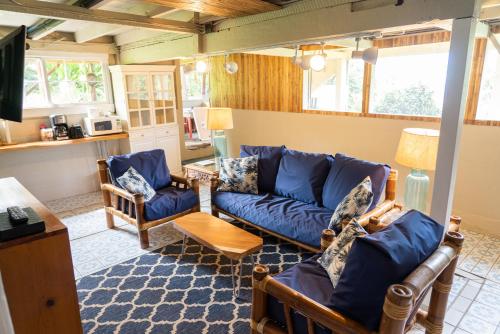 a living room with a blue couch and chairs at Waipi'o Lodge in Kukuihaele