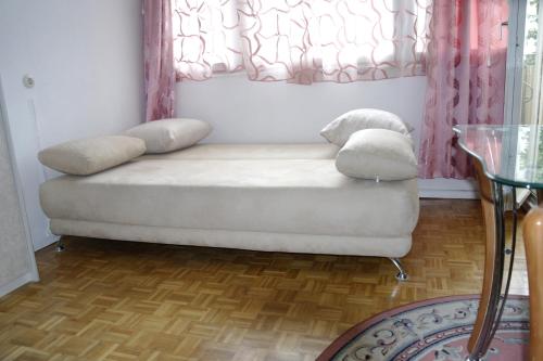 ein weißes Sofa in einem Zimmer mit Fenster in der Unterkunft Kudamm Apartment West Central City in Berlin